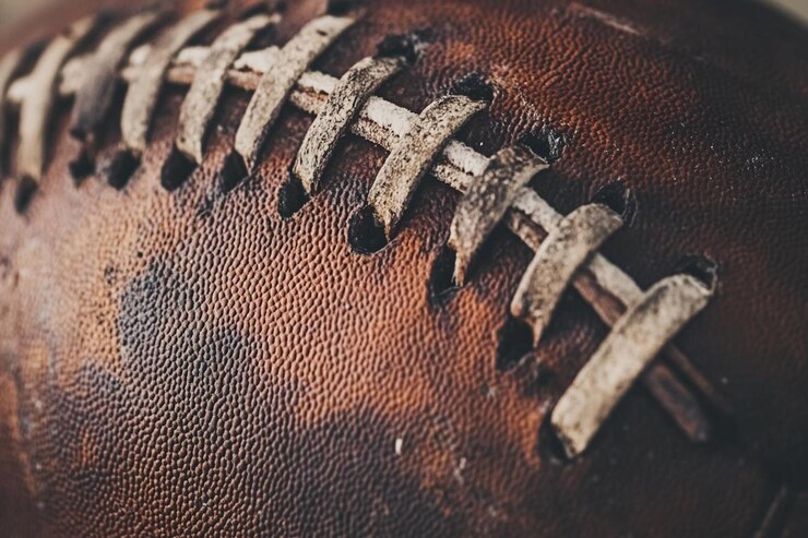 Photo a brown leather football with a black stitching on it