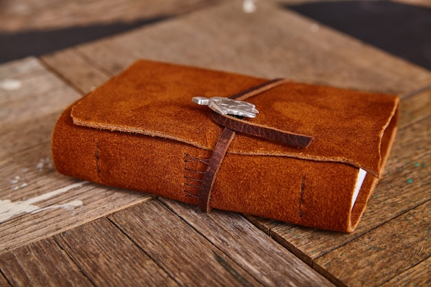 Brown leather journal closed detail on wood boards