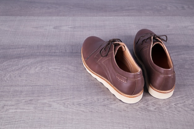 Brown leather men's shoes on wood background