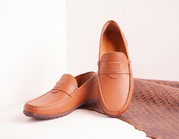 Photo brown leather moccasin shoes on a leather piece