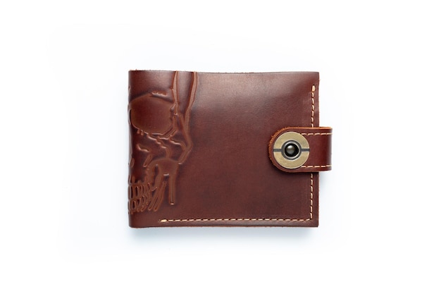 Brown leather wallet on a button on a white background scull print Top view