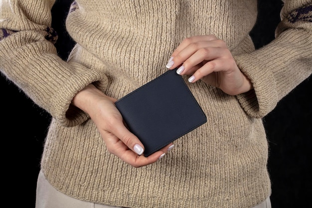 A brown leather wallet is in women's hands