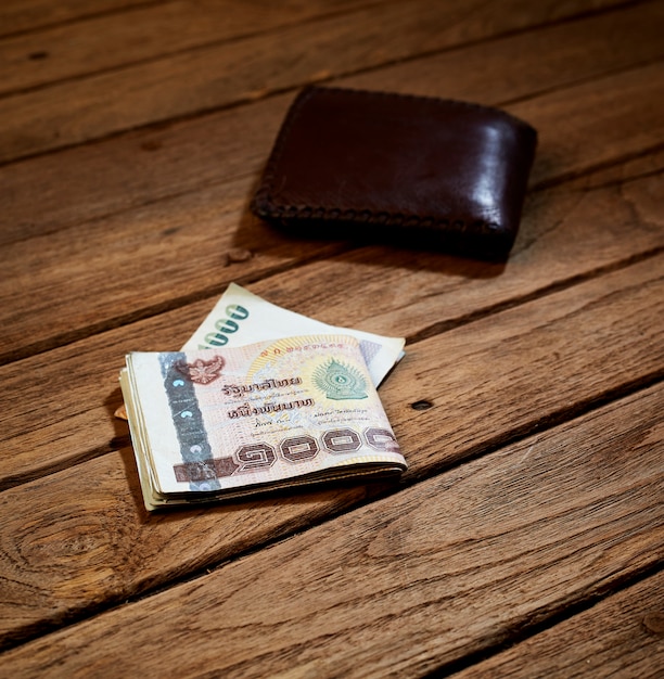 brown leather wallet and Thai money 