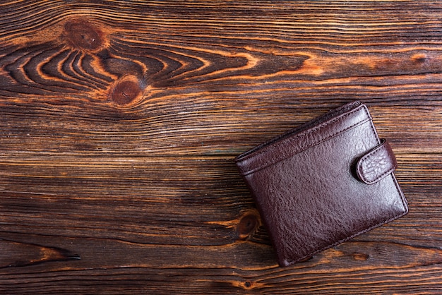 Brown men's wallet on wooden.