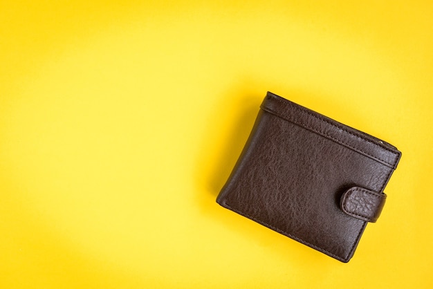 Brown men's wallet on yellow.