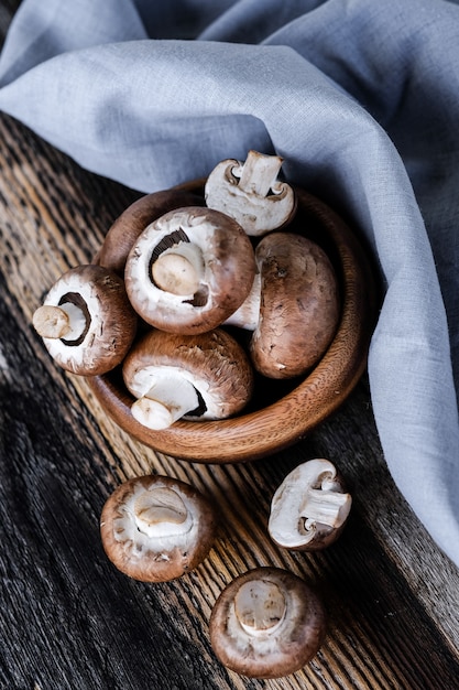 Brown mushrooms on old dark wooden background