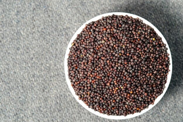 Brown Mustard Seeds in bowl on sackcloth