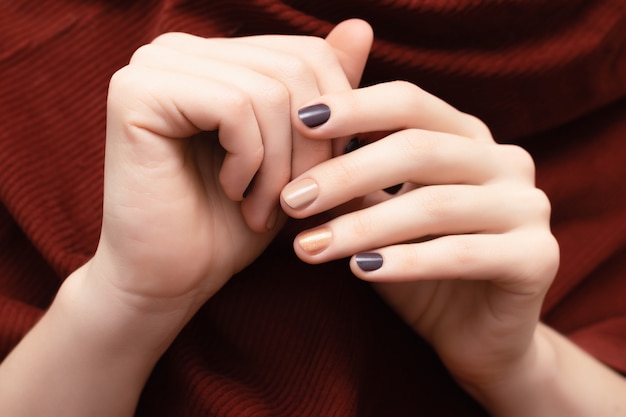 Brown nail design. Female hands with glitter manicure.