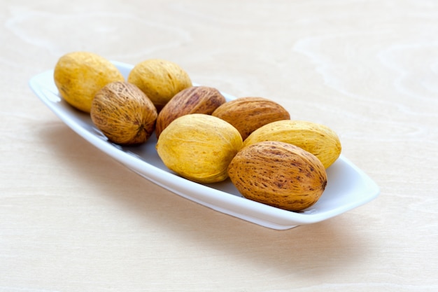 Brown nuts lying in a row on a platter