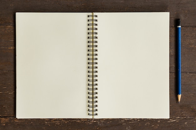 Brown open book with pencil on wood table