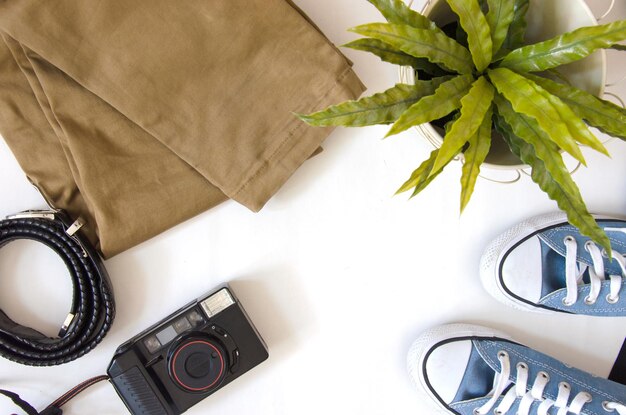 Brown pants camera and shoes Travel accessories on a white background