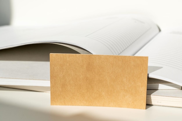 brown paper card placed inside an open notebook stationery and office supplies concept
