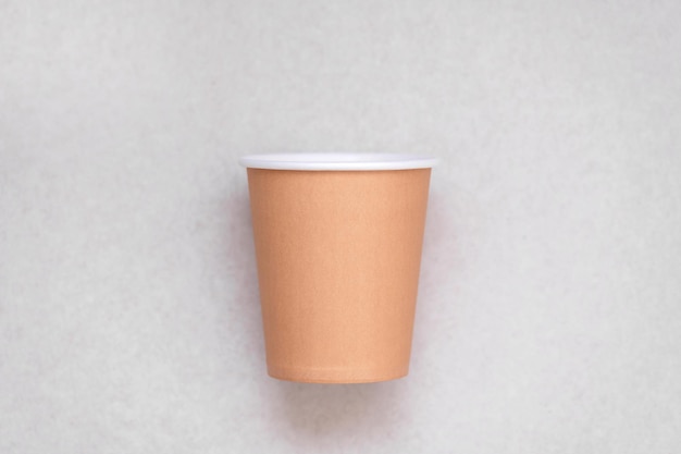 A brown paper cup on a white background with the word coffee on it.