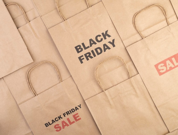 Foto borse della spesa in carta marrone con testo black friday e sale