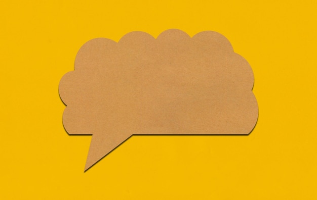 Brown paper speech bubble on yellow paper background