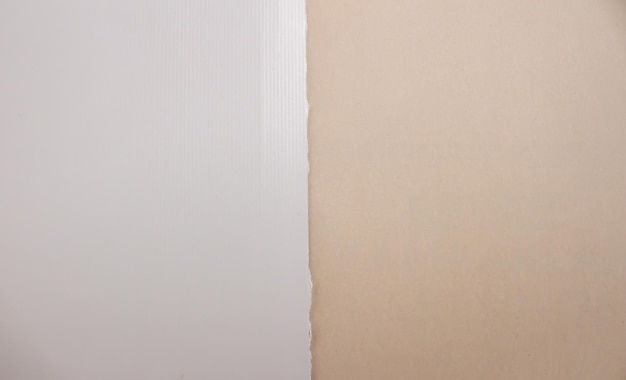 A brown paper with a white strip of paper is on a beige background.