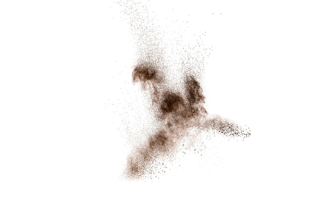 Photo brown particles splash on black background. brown dust exploding.