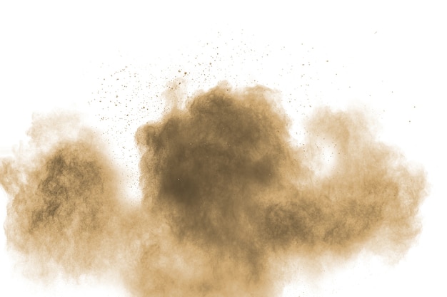 Photo brown particles splattered on white background. brown dust splashing.