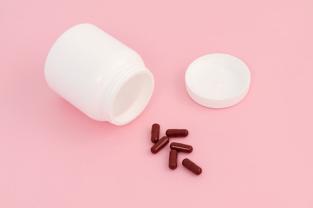 Brown pills near a white jar