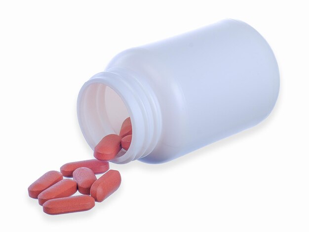 Brown pills and pill bottle on white background with clipping path