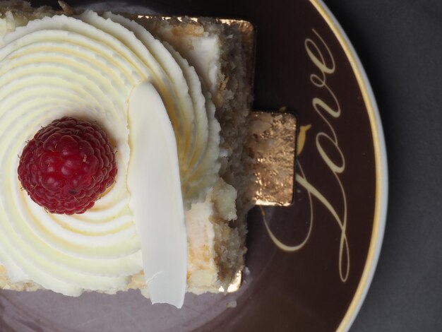 A brown plate with a piece of cake with a cherry on it