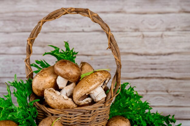 Brown portobello mushrooms in wicker wooden basket with grass decoration