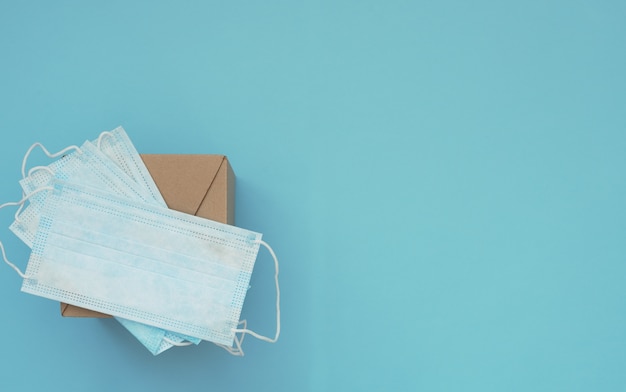 Brown post box with blue medical masks on it on blue background