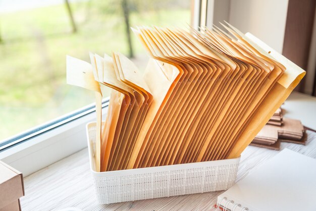 Коричневые почтовые конверты на деревянном офисном столе, рабочей зоне
