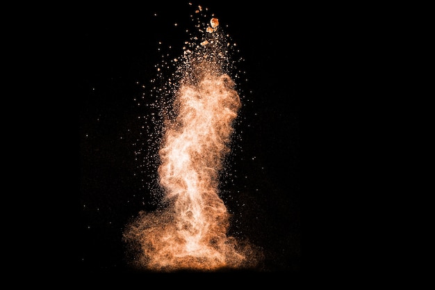 Brown powder explosion on black background.