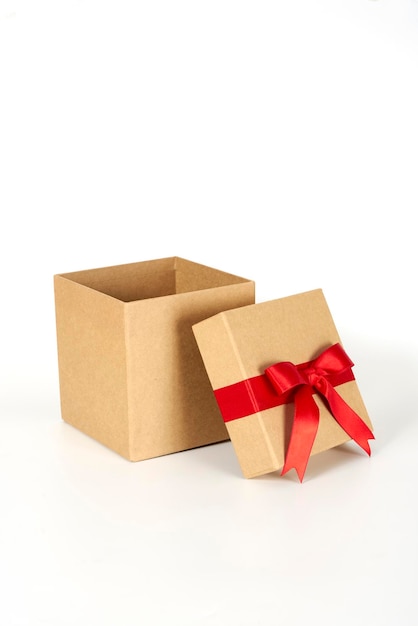 Brown present box with a red ribbon on a white background