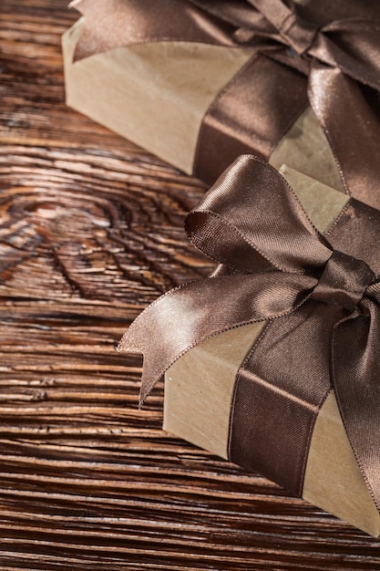 Photo brown present boxes with tied bow on vintage wooden board