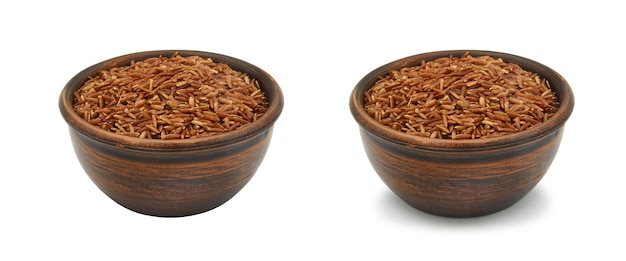 Brown rice in simple clay bowl on white background, isolated and with shadow