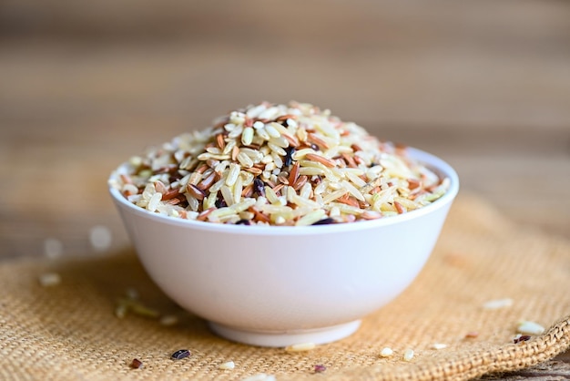 Brown rice on white bowl sack background raw various rice color mixed thai rice for cooking food Loonzain rice brown black red white purple health food