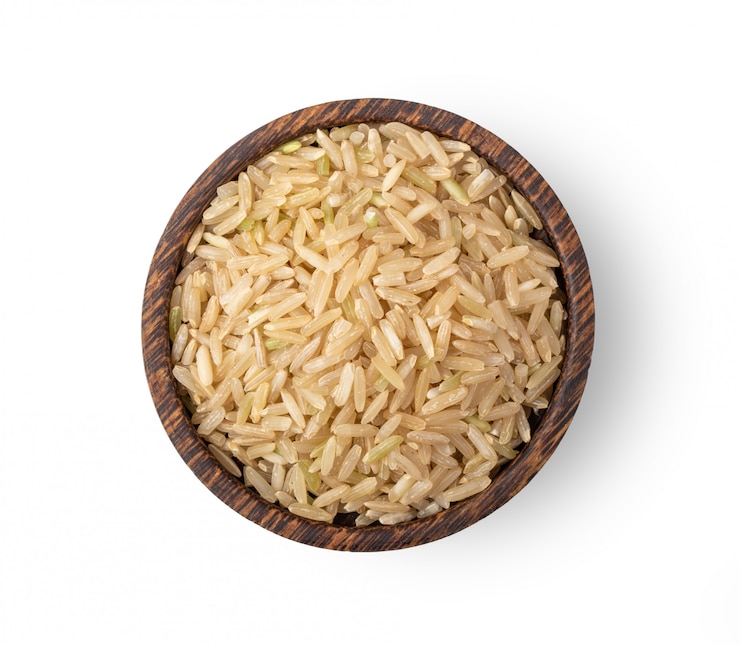 Photo brown rice in wood bowl isolated