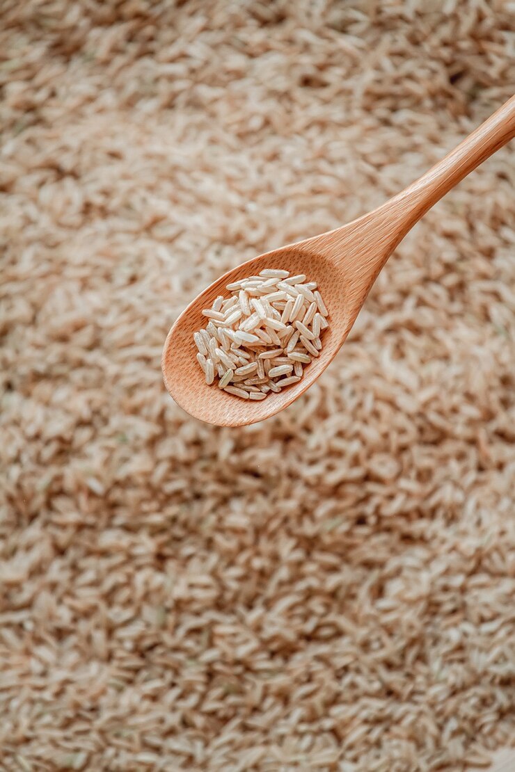 Photo brown rice in wooden or bamboo spoon