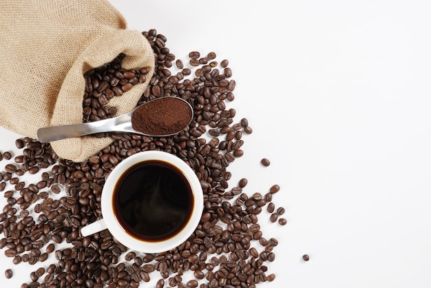 brown roasted coffee beans and coffee cup