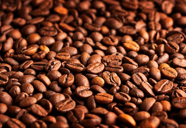 Brown roasted coffee beans making dark natural background used for preparation of espresso drink