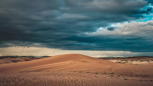 Photo brown sandy land under the dark cloudy grey sky