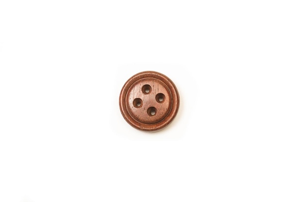 コピースペースのある白い背景の茶色の縫製ボタン