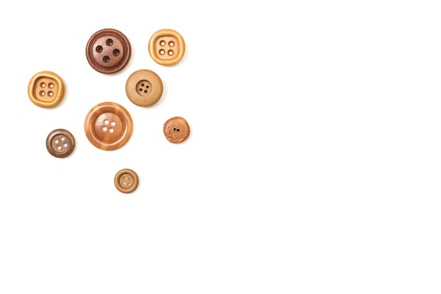 Brown sewing buttons on a white background with copy space