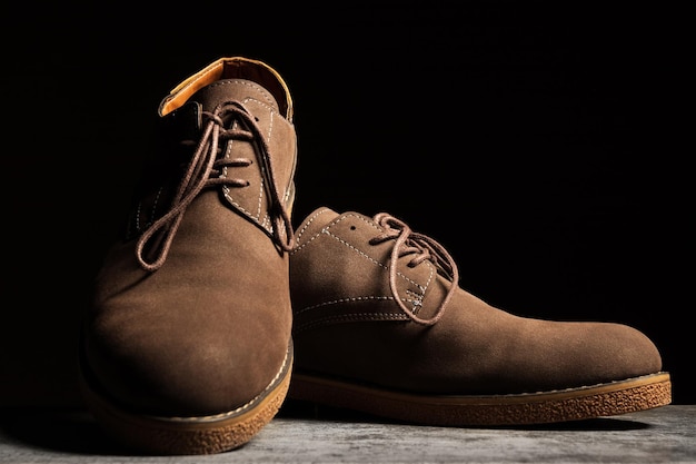 Brown shoes with laces on a black background