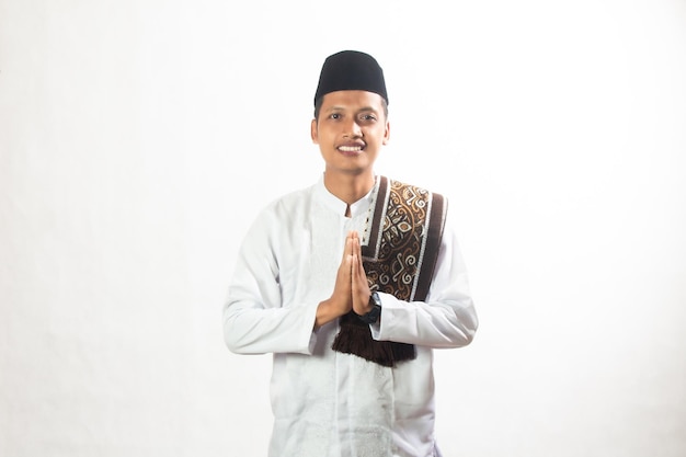 Brown skinned Asian Muslim man smiling while giving a warm greeting isolated studio Ramadan advert