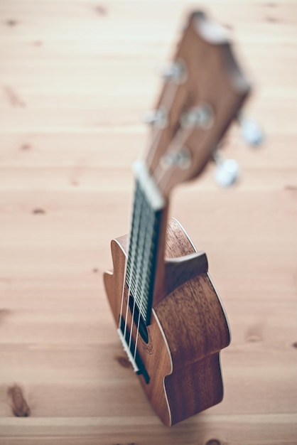 A brown soprano ukulele on wooden background