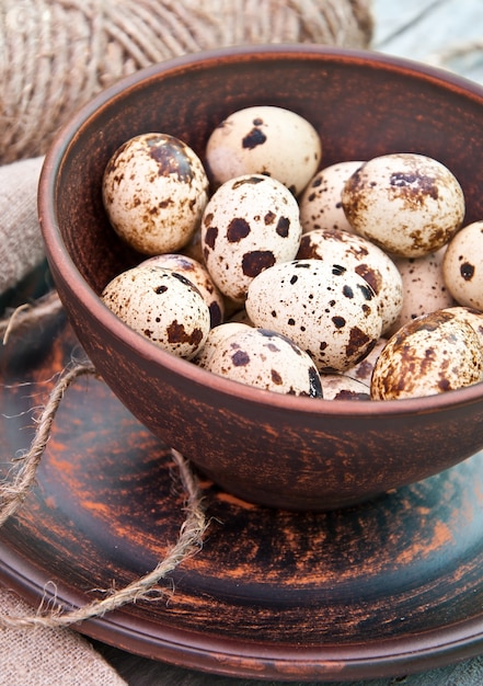 brown spotted quail eggs in ceramic bowl