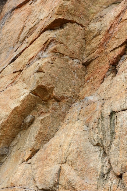 茶色の石または岩の背景岩の自然の詳細クローズアップラフ茶色の石の壁