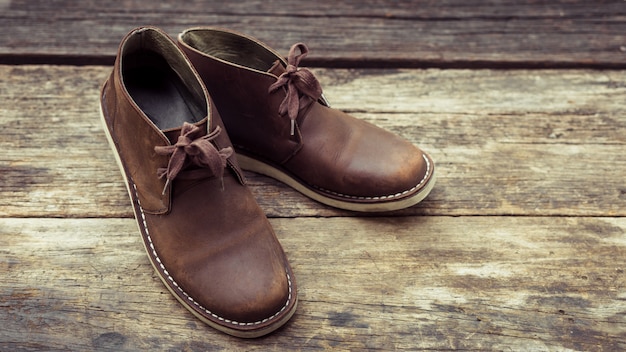 Brown stylish boots on wood ,  retro color