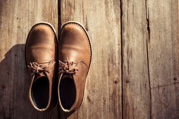 Photo brown stylish boots on wood, retro color