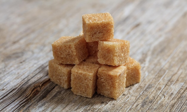 Brown sugar cubes on a wooden surface