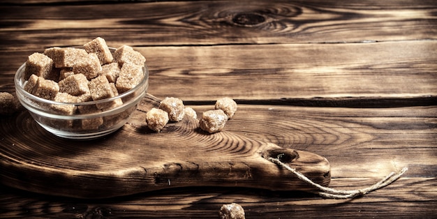 Brown sugar in a Cup on wooden table.