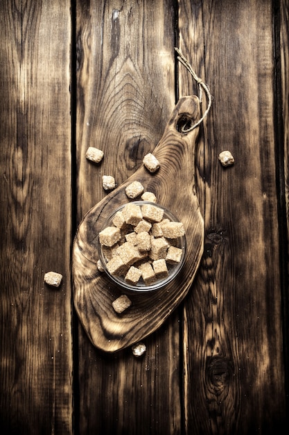 Brown sugar in a Cup on wooden table.